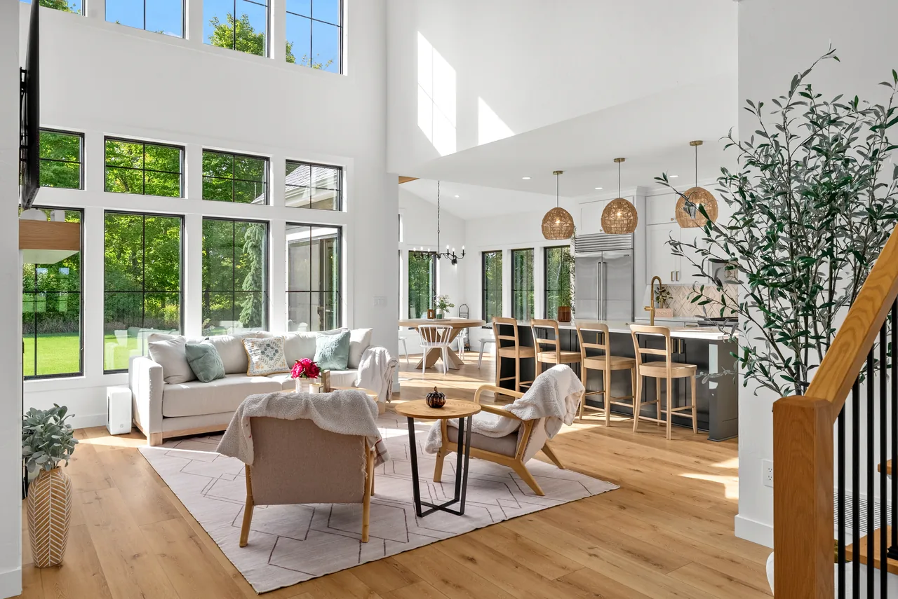 Double-height living room with tall windows and an open kitchen