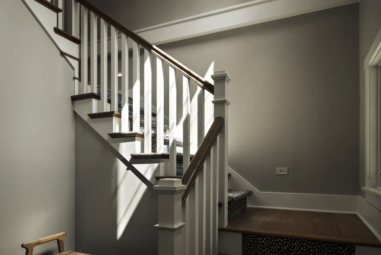 Interior staircase with dark railings and light walls