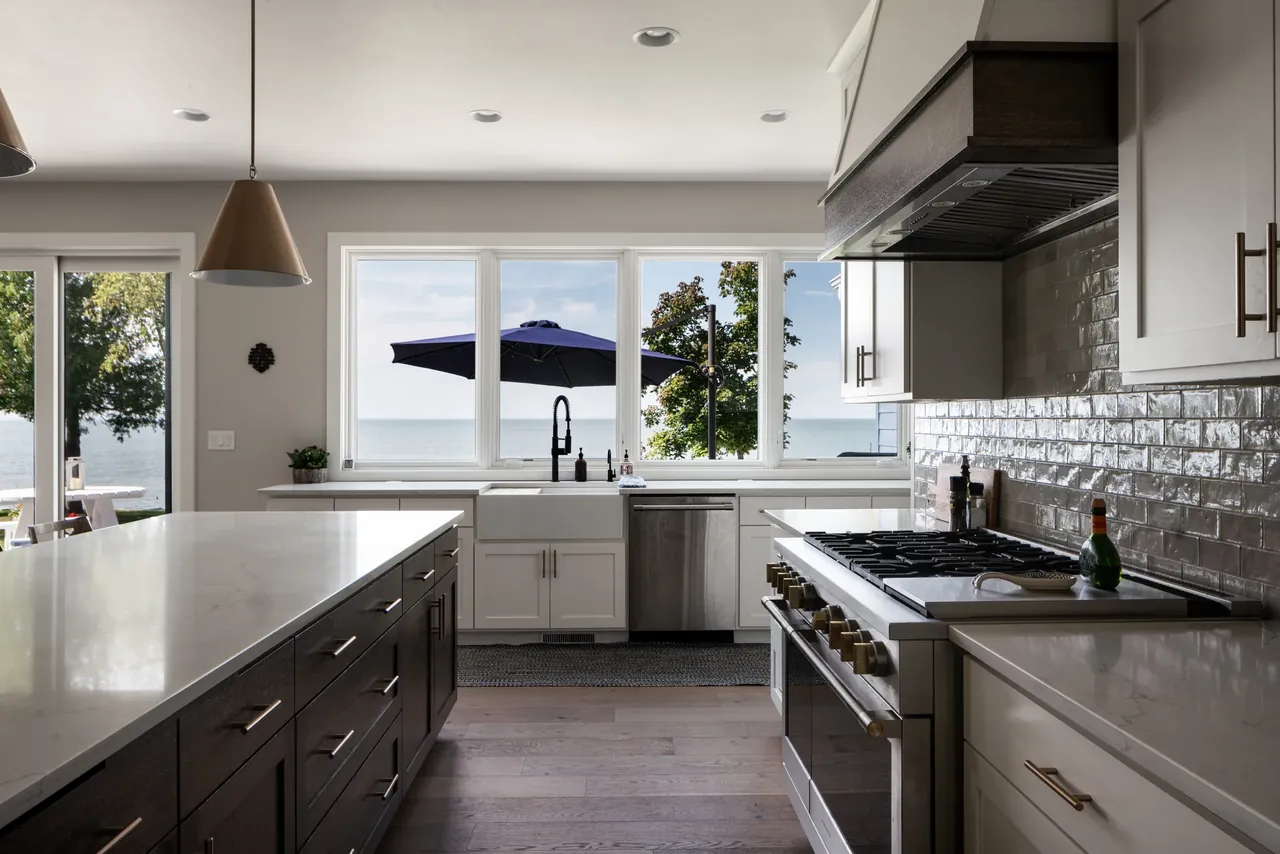 Kitchen with white cabinetry, dark counters and a bright corner window