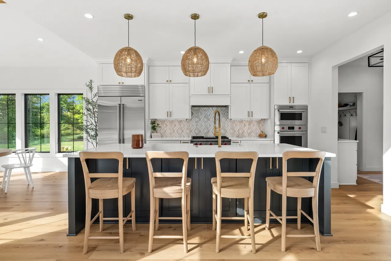 Kitchen island with glass globe pendant lights and a row of stools