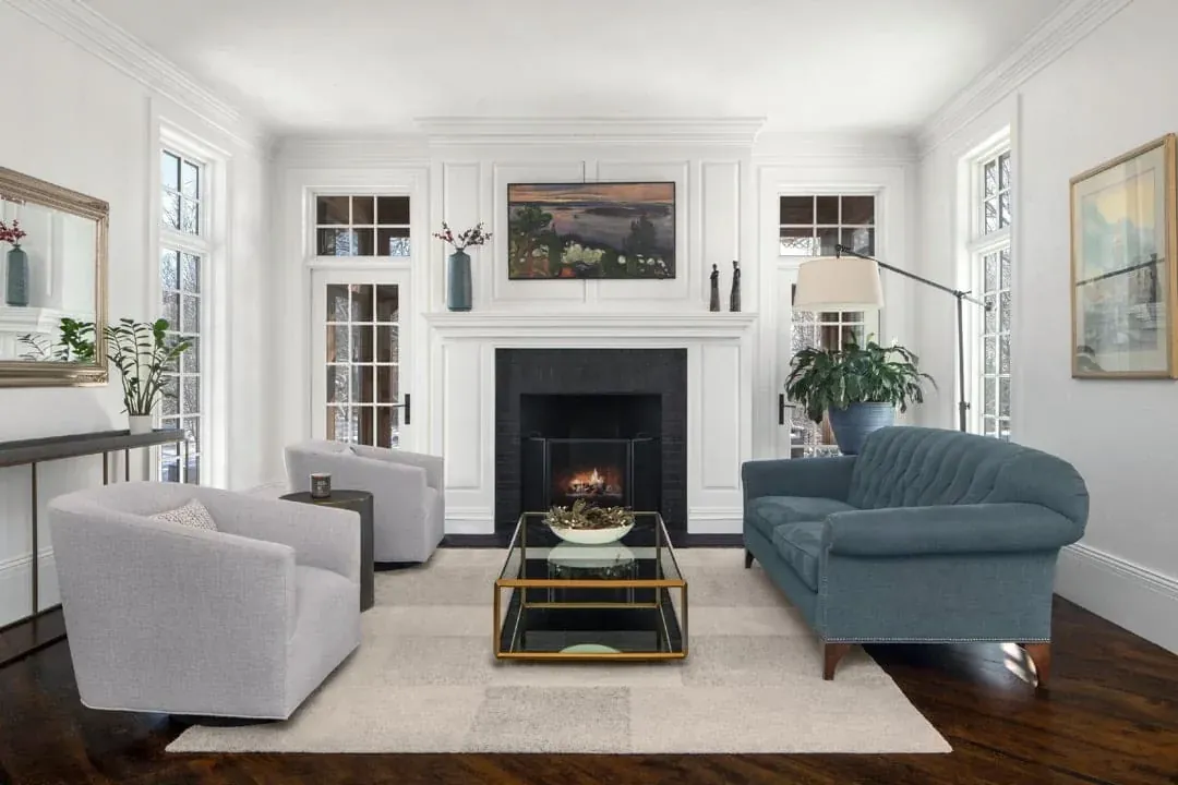 Bright living room with a white fireplace, blue-gray armchair and patterned rug