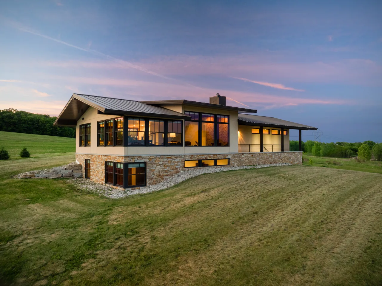 Elevated twilight view of a modern home with glowing windows