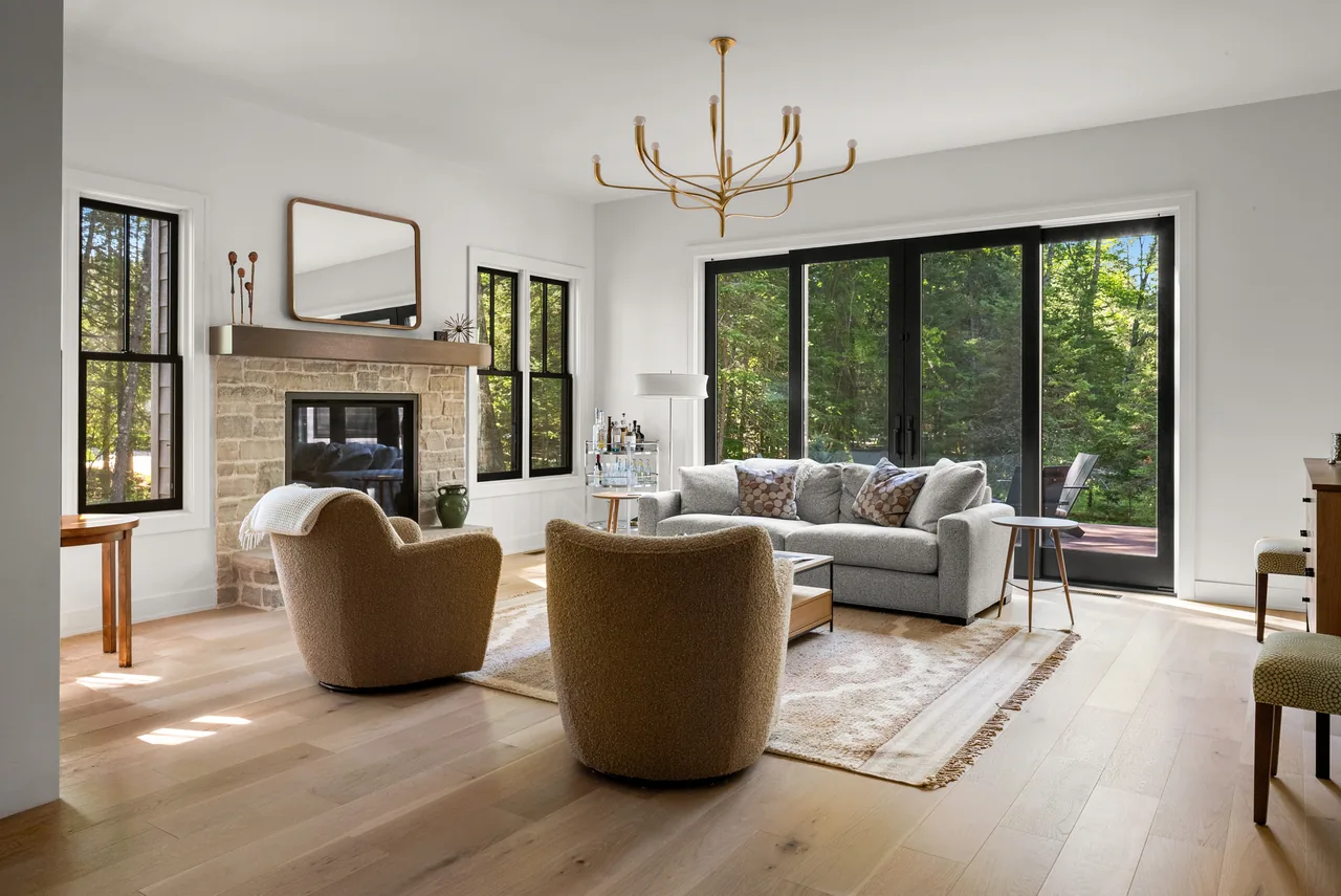 Sunlit living room with curved tan chairs facing tall windows