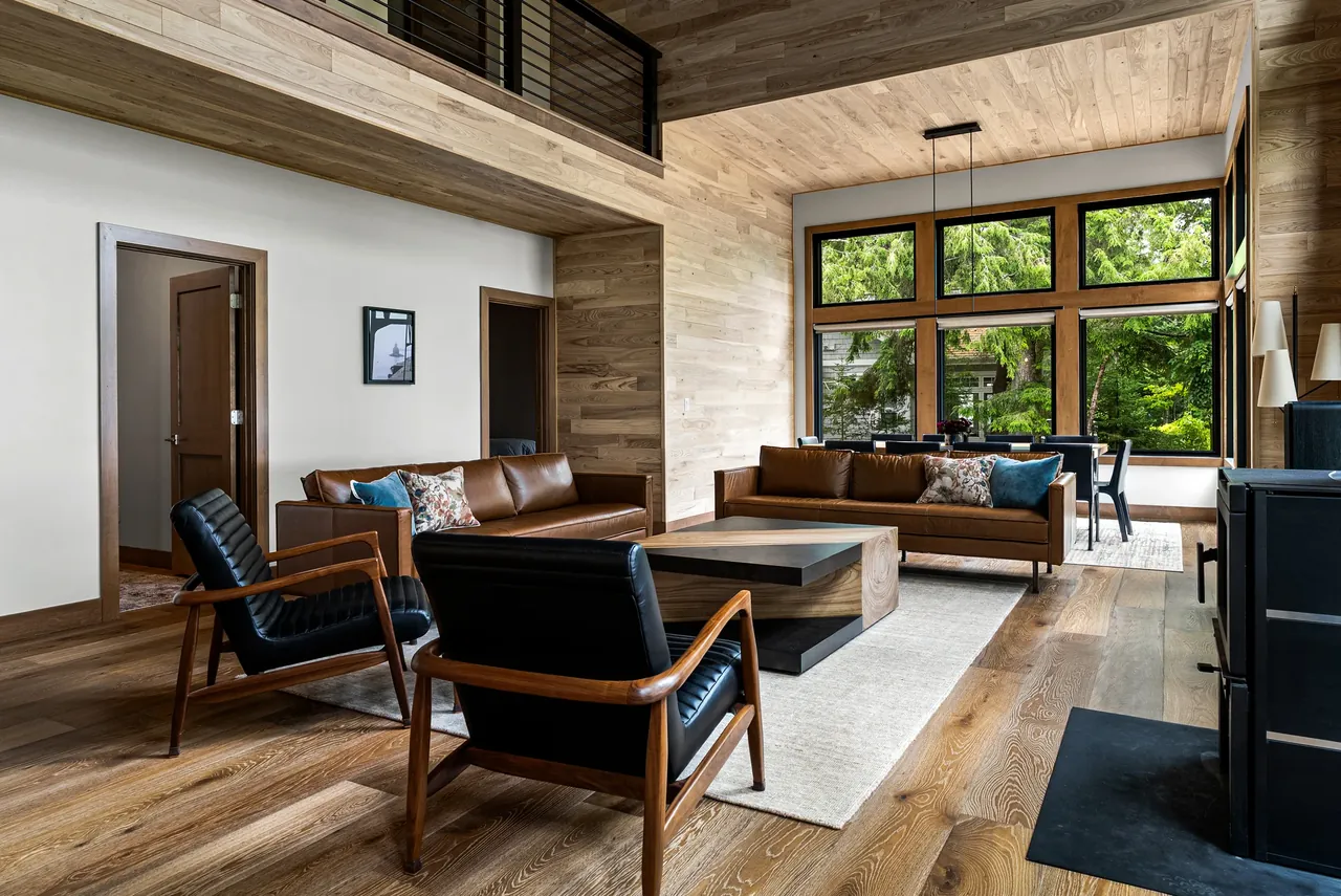 Living room with a wood ceiling, fireplace and broad garden-facing windows